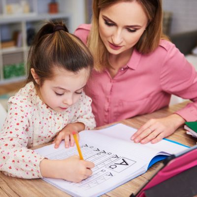 young-woman-helping-girl-with-homework-8BSC5RF.jpg